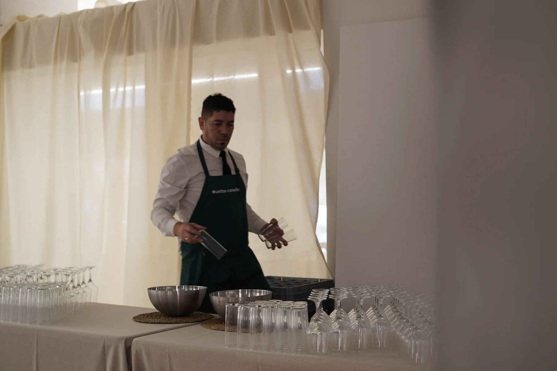 Camarero Duetto preparando cristalería y barra antes de un cóctel de Navidad