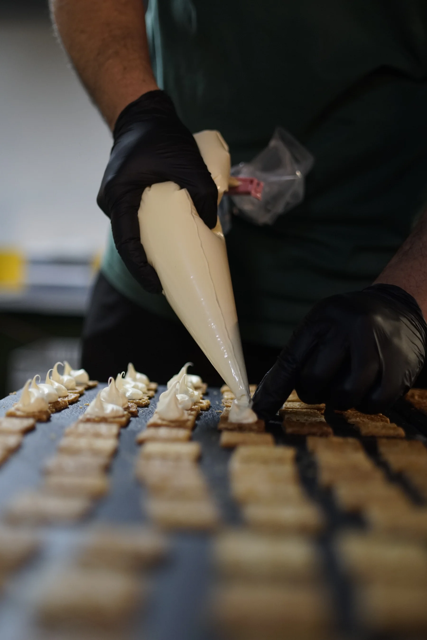 Cocina con guantes preparando producto para evento privado