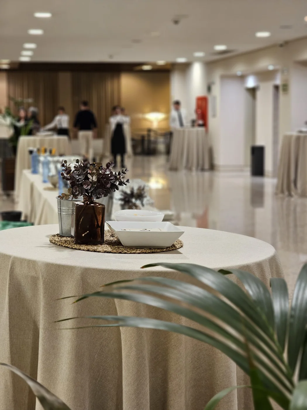 Mesas cóctel altas montadas con centros florales para cumpleaños en salón privado