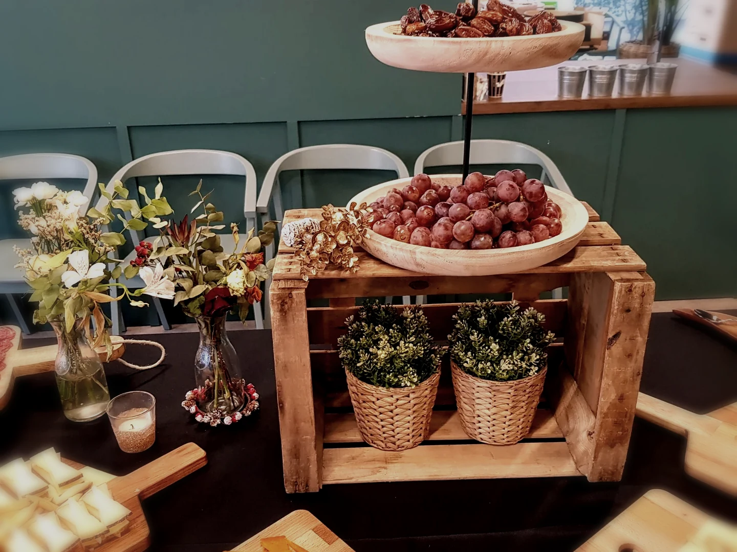 Detalle editorial de mesa de evento con uvas, flores secas y velas en montaje Duetto